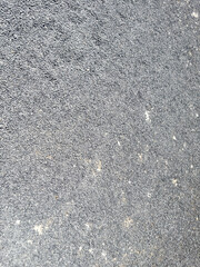 Rough gray asphalt texture with small pebbles and specks