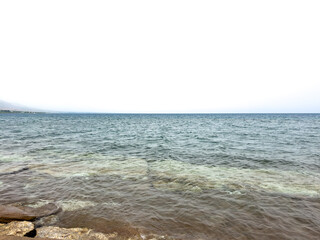 Rocky shore and clear water of Issyk-Kul under a vast sky
