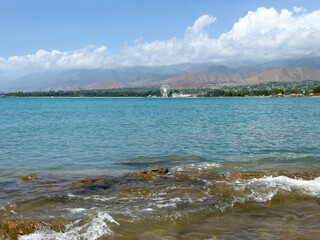 Rocky shore and clear water of Issyk-Kul under a vast sky