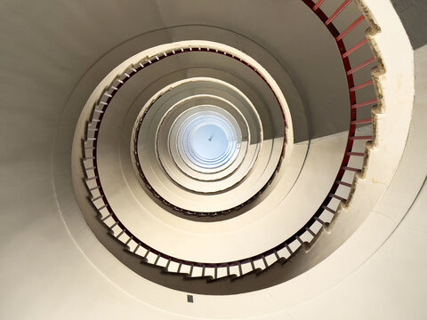 Abstract spiral staircase with minimalist design and red railings