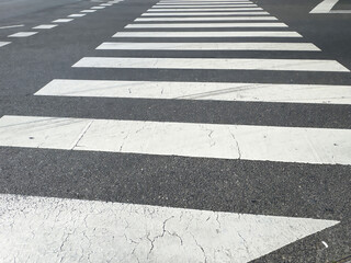 Empty crosswalk on asphalt road with white stripes