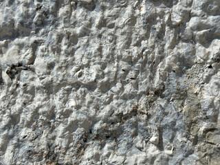 Rugged texture of weathered gray stone surface with visible erosion patterns
