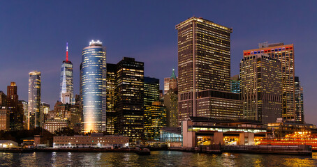Naklejka premium A vibrant sunset panorama of Manhattan downtown skyline, viewed from the river