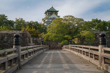 Obraz premium Osaka Castle from the side of the Gokuraku-bashi Bridge over the Inner Moat on a sunny autumn morning, Osaka, Japan