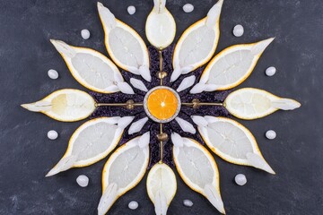 A symmetrical arrangement of citrus slices and small stones.