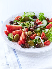 Healthy and tasty salad with , various tomatoes, olives, cucumber, onion and lettuce.	