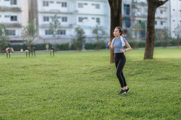 An Asian woman stretches and goes for a run in a public park, embracing outdoor exercise and a...