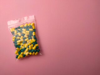 Top view of a medicine pill package on a pink background with copy space