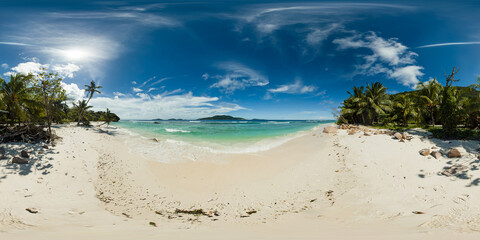 A serene tropical beach with soft white sand and crystal waters, bordered by lush palm trees. Anse grosse rocche beach. La Digue, Seychelles. 360 panorama VR.