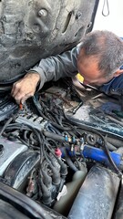 male mechanic repairing car engine