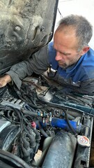 male mechanic repairing car engine