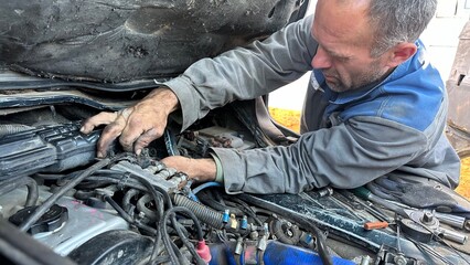 male mechanic repairing car engine