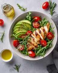 Fresh grilled chicken salad with avocado and cherry tomatoes on arugula