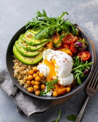 Healthy breakfast bowl with poached egg quinoa avocado and fresh vegetables