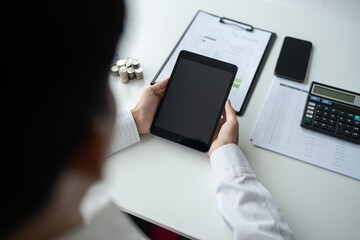 Business man holding digital tablet using Stock market application and reviews finances and manages budget with money cash