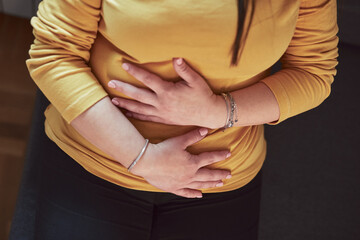 Woman with strong stomach ache, menstrual and digestive issues at home.
