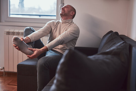 Man with ankle and foot pain at home.