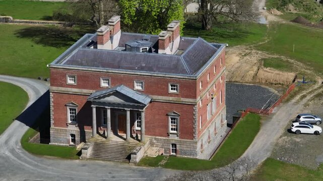 Bellamont House, County Cavan, Ireland, April 2023. Drone circling clockwise from front of Georgian architecture, spring greenery and elegant estate on sunny day.