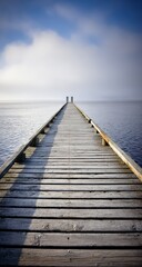 Naklejka premium Wooden pier extending into tranquil lake