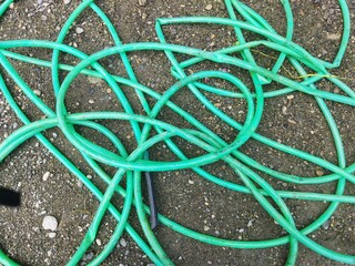 The hose is tangled on the ground.