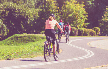 Fototapeta premium Cyclists ride on the bike path in the city Park