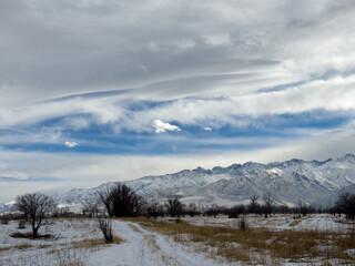 Snow covered mountains in Kyrgyzstan under cloudy winter sky peaceful rural landscape