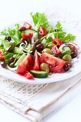 Healthy and tasty salad with , various tomatoes, olives, cucumber, onion and lettuce.	