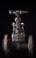 Industrial high-pressure shut-off valve made of metal, isolated on a dark background.