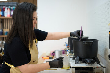 Candle maker preparing wax in workshop for handmade candles