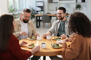 Colleagues chatting during lunch break in office