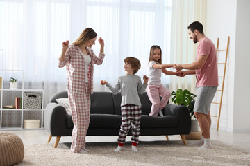 Happy family wearing stylish pajamas having fun at home