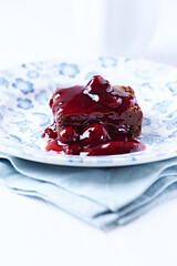 Chocolate brownie with cherry syrup . Selective focus. Copy space.	