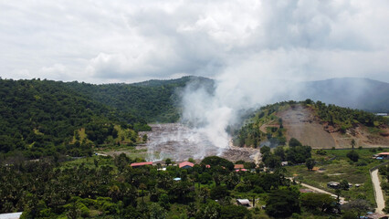 Aerial view of landfill with smoke from burning rubbish in Tibar, Dili Timor-Leste