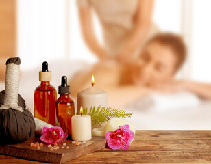 Spa therapy. Woman receiving massage on table and composition with herbal bags and body care...