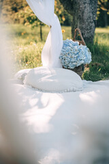 Spacious garden setting with white pillows and blue flowers under a tree
