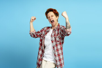 Enthusiastic designer celebrating success with raised fists and cheerful expression