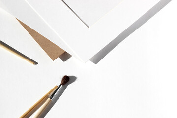 Passepartout, White Sheet of Kraft Paper, Cardboard and Painting Brushes Layout on White...