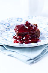 Chocolate brownie with cherry syrup . Selective focus. Copy space.	