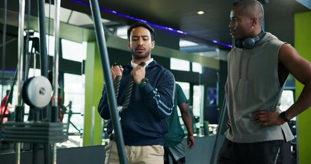 Men, fitness coach or weightlifting with demonstration on cable pulley machine for arm exercise. Male people, instructor and helping client with training technique for workout tips or health at gym