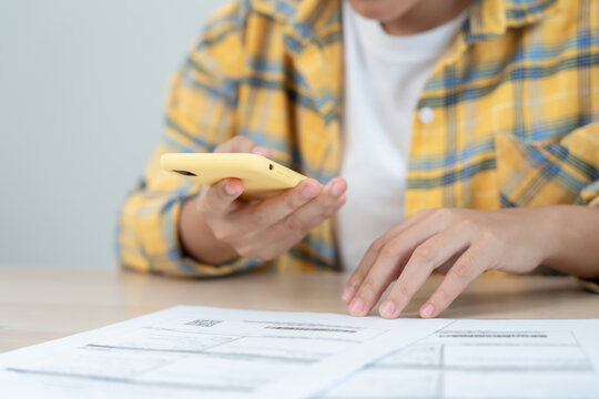 Modern female use phone to scan barcode or QR codes to pay credit card bill after receive document invoice. payment, receive, paying electricity, digital payments without money, technology, scanning