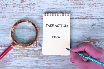 Encouraging motivation, productivity and determination concept. TAKE ACTION NOW on a handwritten...