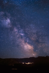 The Milky Way over the mountains of the Balagne region of Corsica with the lights of the village of Speloncato in the distance