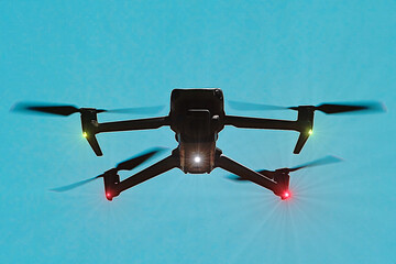 Dron no tripulado con cámara, hélices y luces verdes, rojas y blancas sobrevolando el cielo
