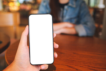 Mockup image of a man holding mobile phone with blank screen  with a woman in background