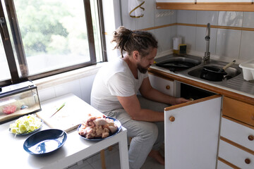 Man composting organic chicken waste in his home kitchen