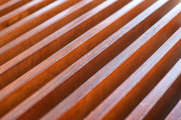 Close-up of wooden slats with regular pattern and warm natural tones in abstract design.