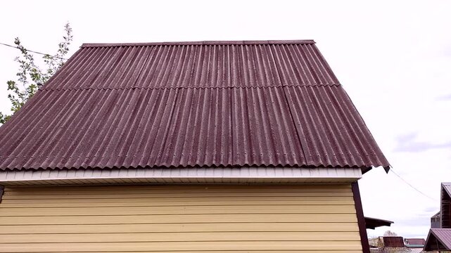 Facade of a new single-story rural house clad with siding, wall and roof