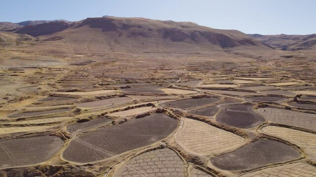 4K Aerial shot of dry farms in mountains of Spiti Valley, Himachal Pradesh, India. Drought and bad harvest. Parched land on crops field due to hot and dry summer. Global warming concept.