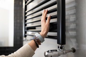 Female Hand Adjusting The Temperature Of The Radiator