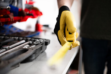 Auto Mechanic Holding Measuring Tape In Hands
